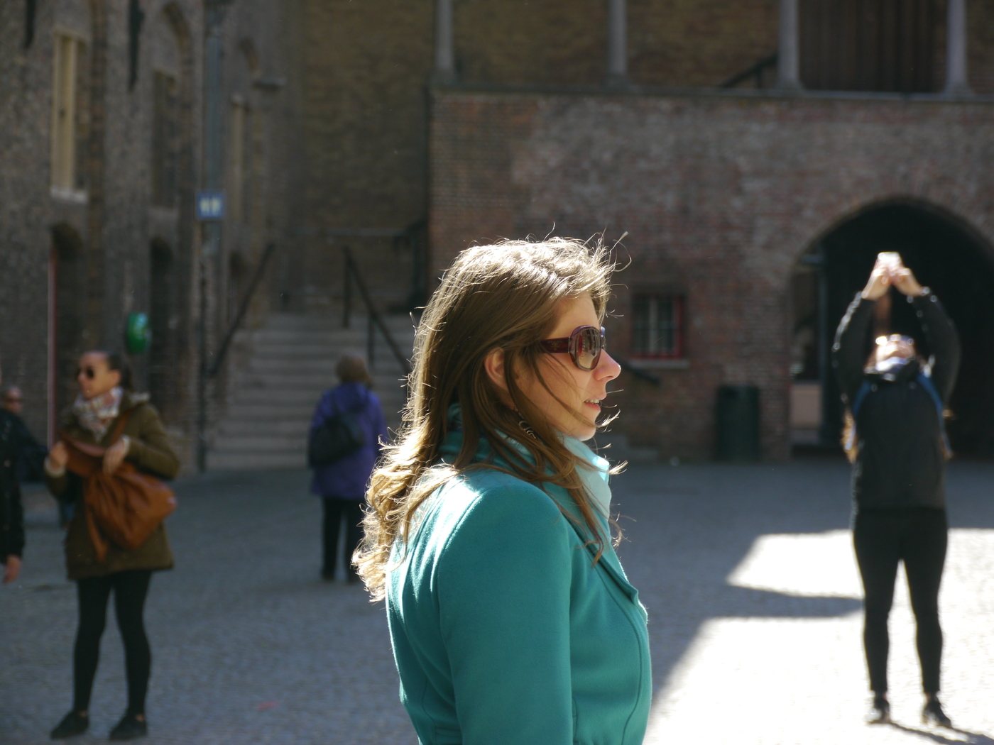Mirela in foreground with tourists and Bruges architecture in the background