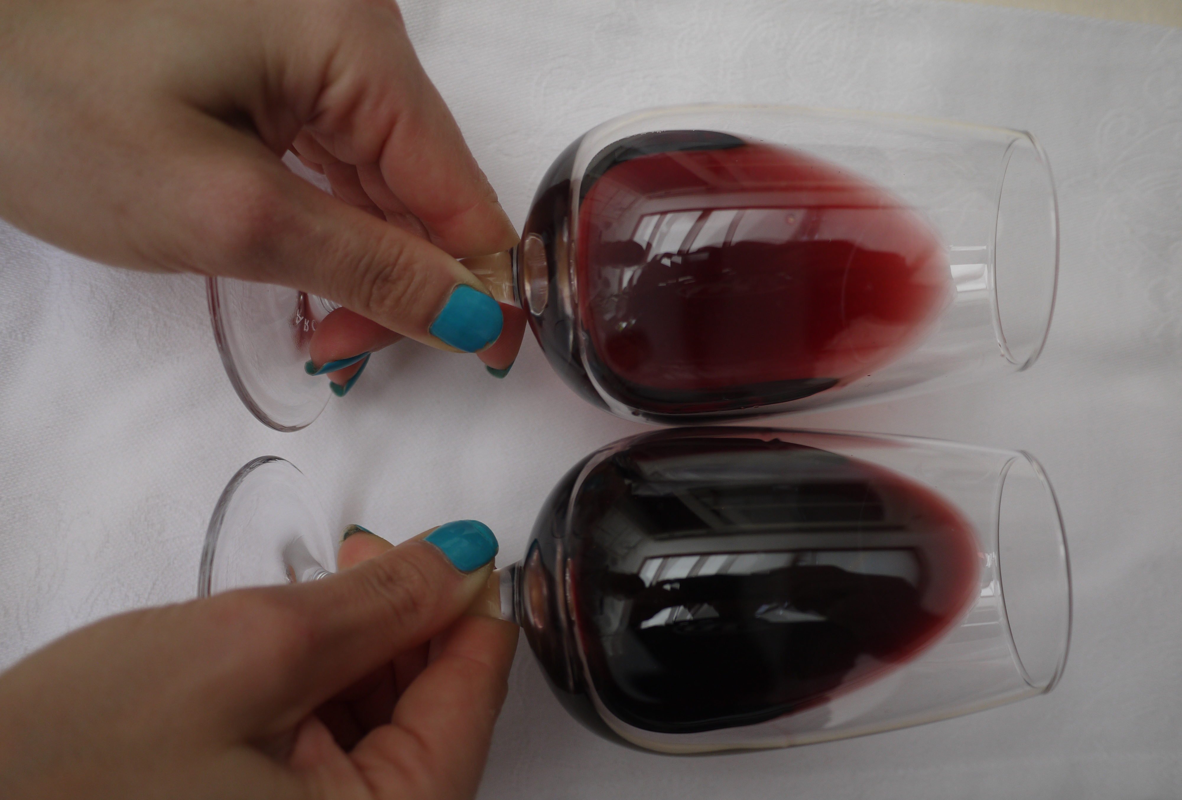 Holding wine at an angle to assess colour intensity: here showing medium and deep ruby.