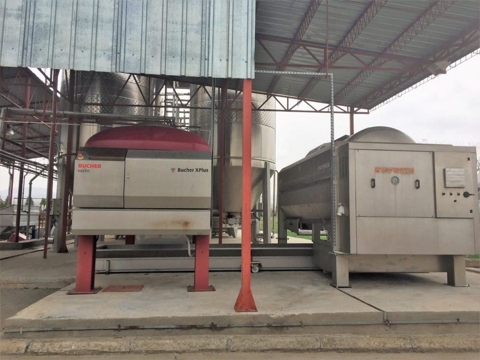 Modern horizontal pneumatic grape presses at Aurelia Vișinescu and fermentation tanks in the background